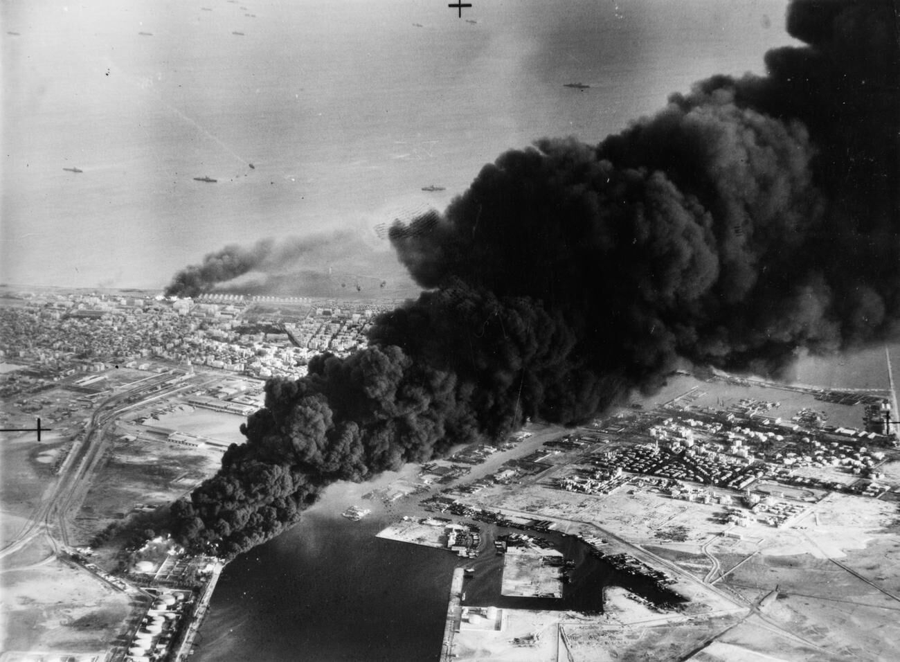 Aerial photograph of Port Said with smoke rising from oil tanks beside the Suez Canal